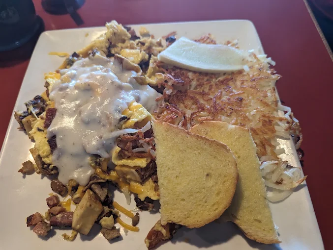 Country gravy over a loaded omelette with hash browns and toast